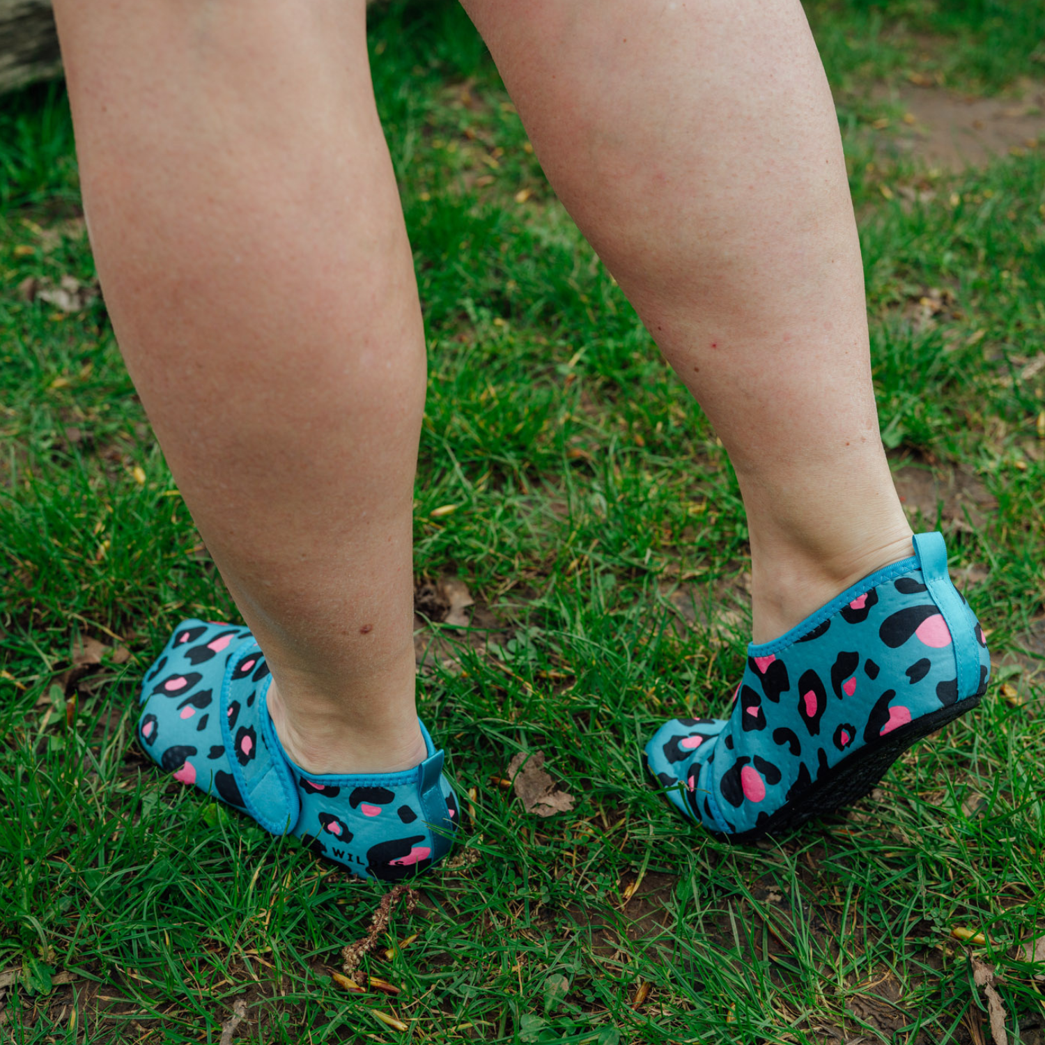 Blue leopard print neoprene beach shoes on a wooden floor