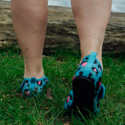 Blue leopard print neoprene beach shoes on a wooden floor