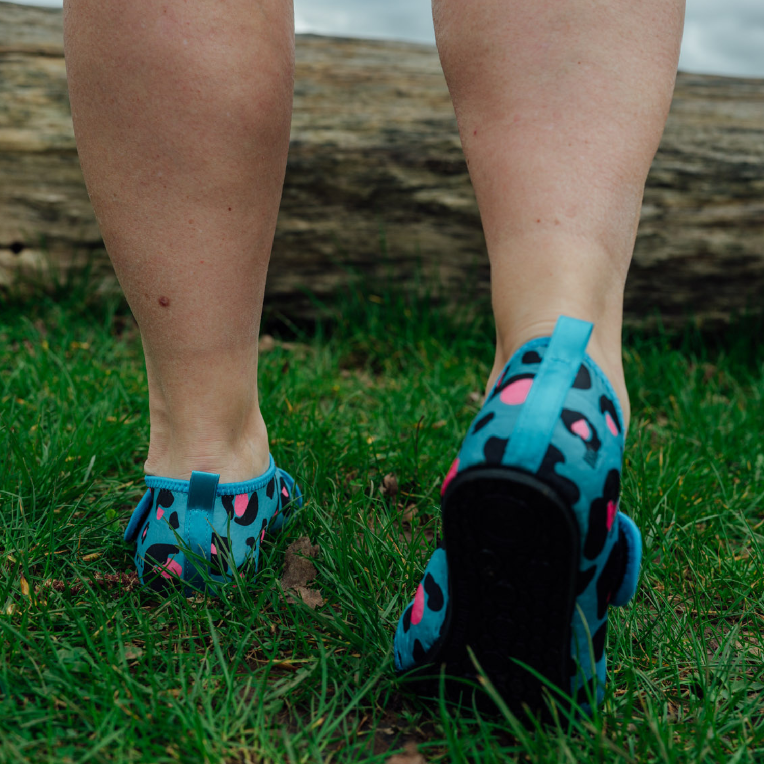 Blue leopard print neoprene beach shoes on a wooden floor