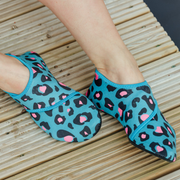 Blue leopard print neoprene beach shoes on a wooden floor