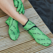 Green neoprene gloves with whale pattern on a wooden surface