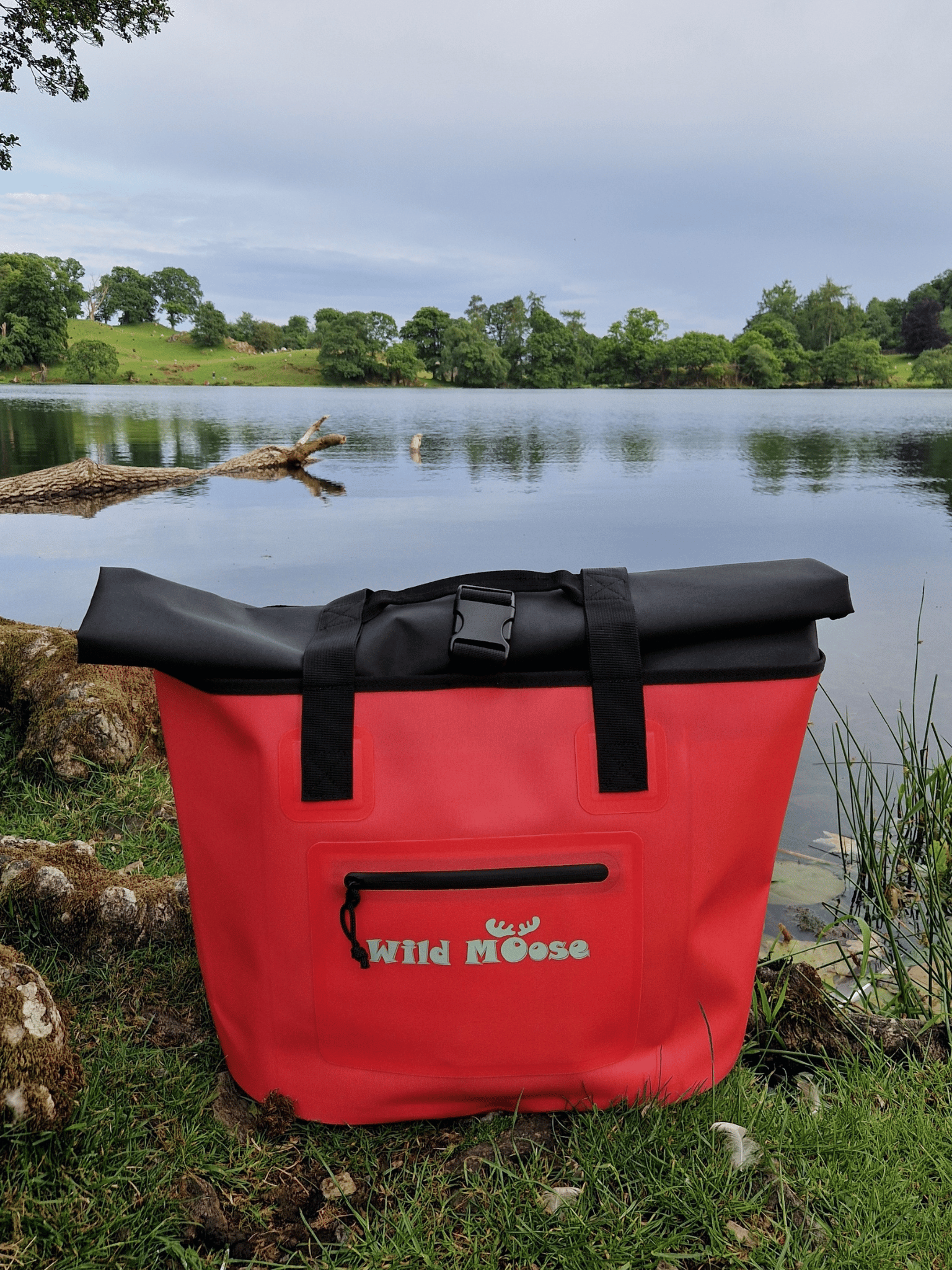 product shot of a coral coloured Wild Moose tote bag on the shores of a Lakeland tarn