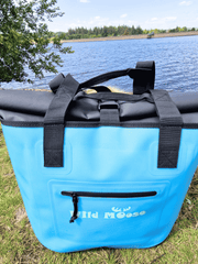 a bright blue tote bag with Wild Moose logo next to a body of water